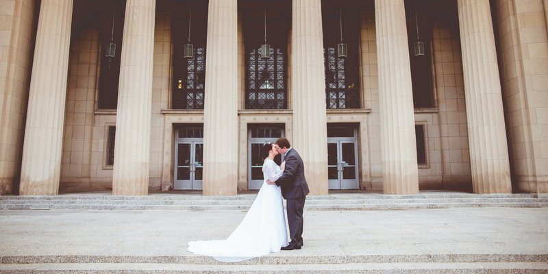 Central PA bride and groom kissing on the steps in front of the grand columns of the courthouse