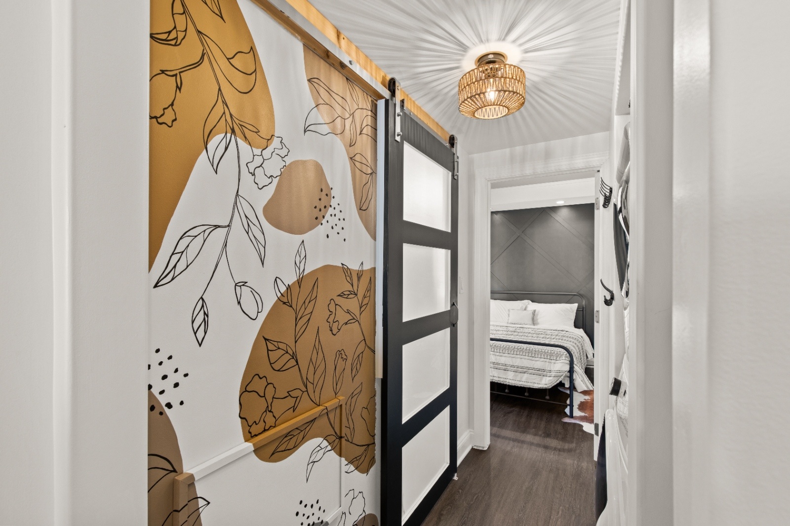 Luxury on Lemon Hallway with Mural and Sliding Barn Door Decorative hallway at Luxury on Lemon Airbnb in Lancaster, PA with abstract mural wall and modern sliding barn door leading to bedroom.