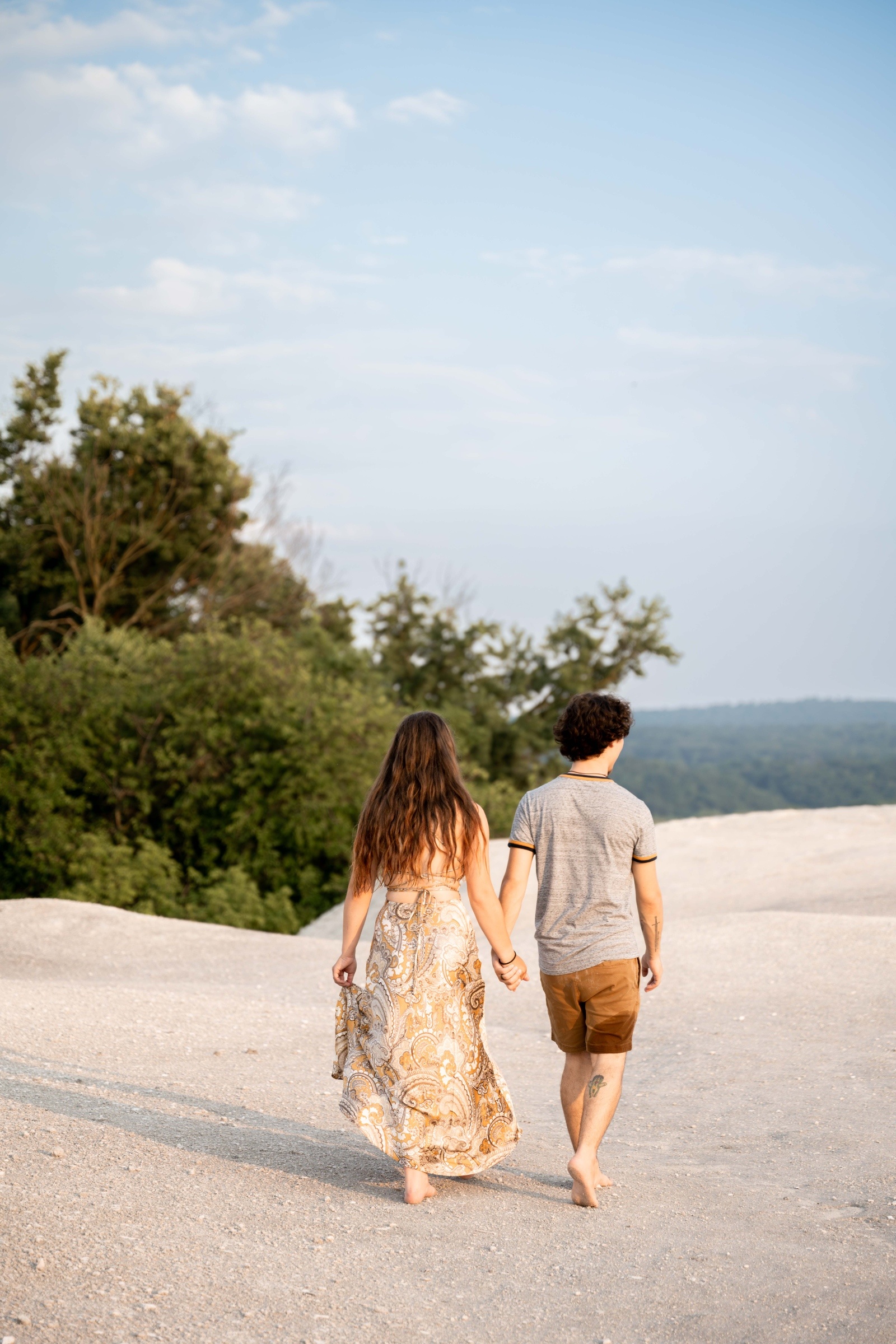 Couple holding hands while walking barefoot across the white limestone cliffs overlooking the Susquehanna River in Central PA.