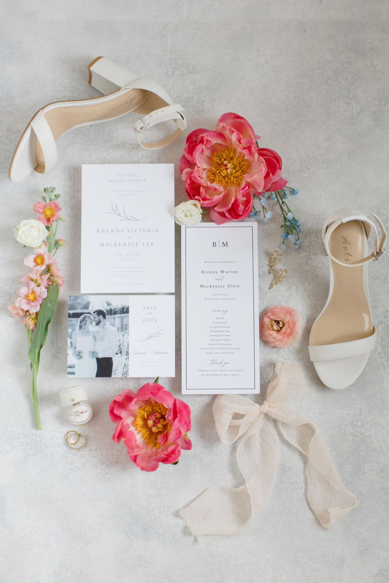 Wedding Flat Lay with Bridal Shoes, Ring Box, and Invitation Suite Wedding flat lay with bridal shoes, engagement ring, invitation suite, ribbon, and pink florals styled for wedding detail photos.
