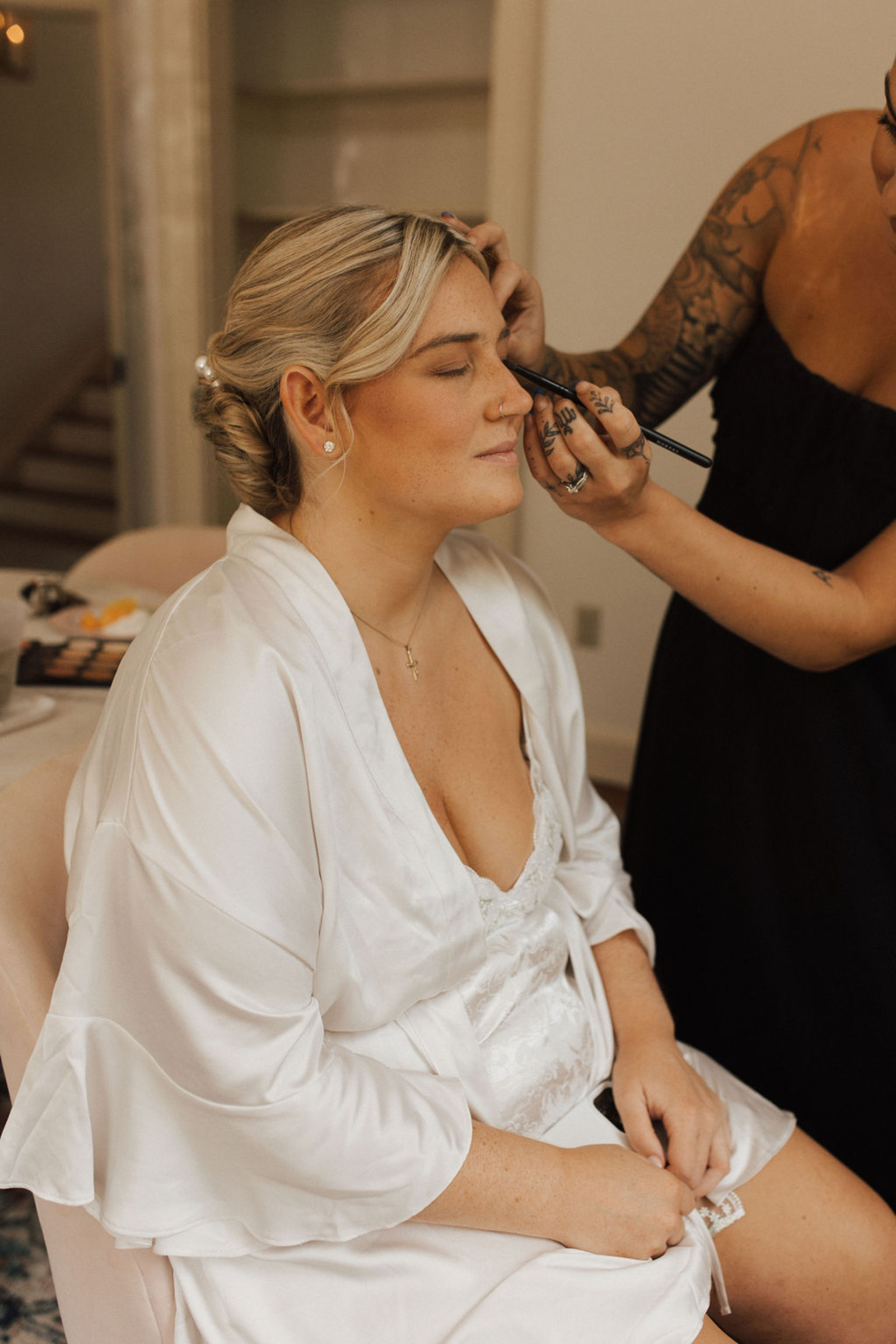 Central PA bride in a silk white robe getting her makeup done