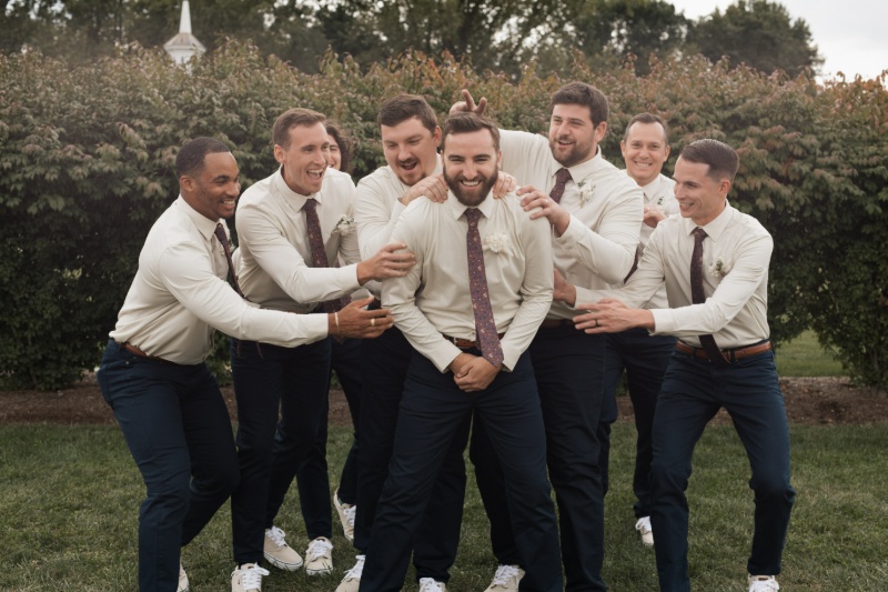 Groom laughing with his groomsmen during wedding party portraits at St. Michael’s Vineyard.