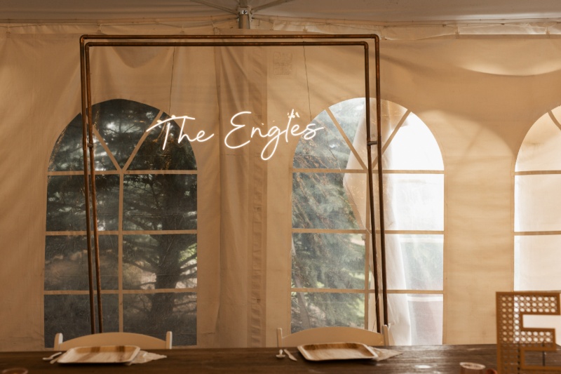 Custom neon wedding sign reading “The Engles” displayed behind the sweetheart table at St. Michael’s Vineyard.