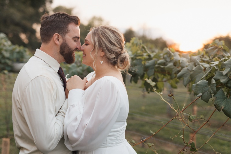 Bride and groom sharing a close sunset portrait beside the vineyard rows at St. Michael’s Vineyard.