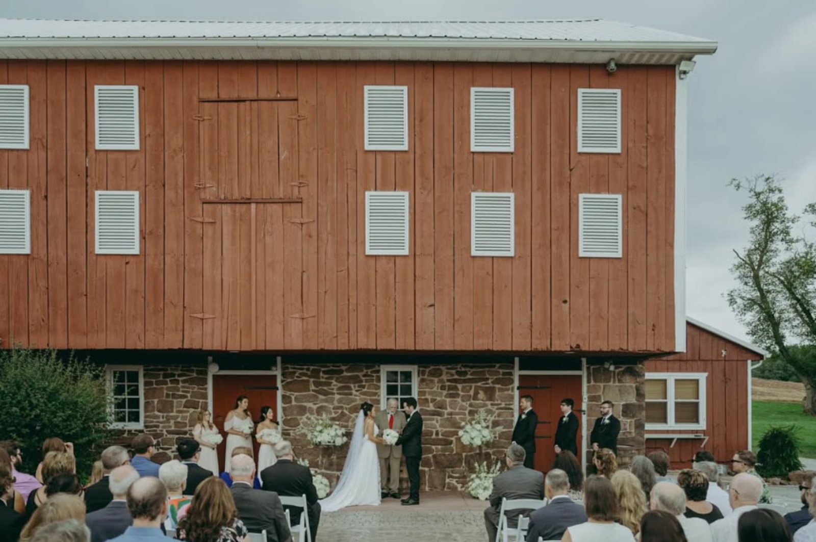 Outdoor wedding ceremony in front of the historic barn at The Looking Barn in Fairfield, PA.