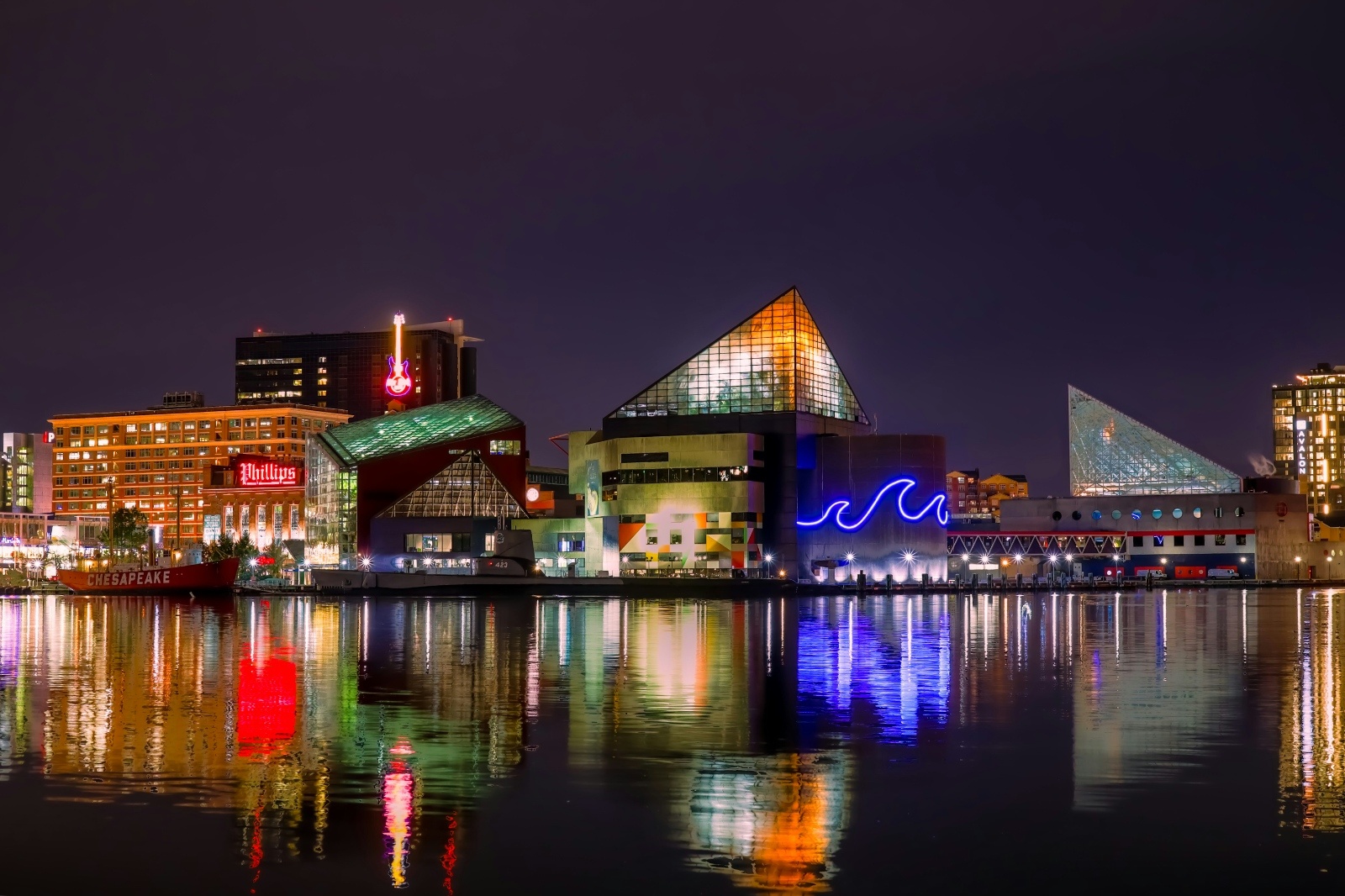 Colorful night view of Baltimore’s Inner Harbor with city lights reflecting on the water — showcasing the vibrant nightlife perfect for a bachelorette weekend getaway.