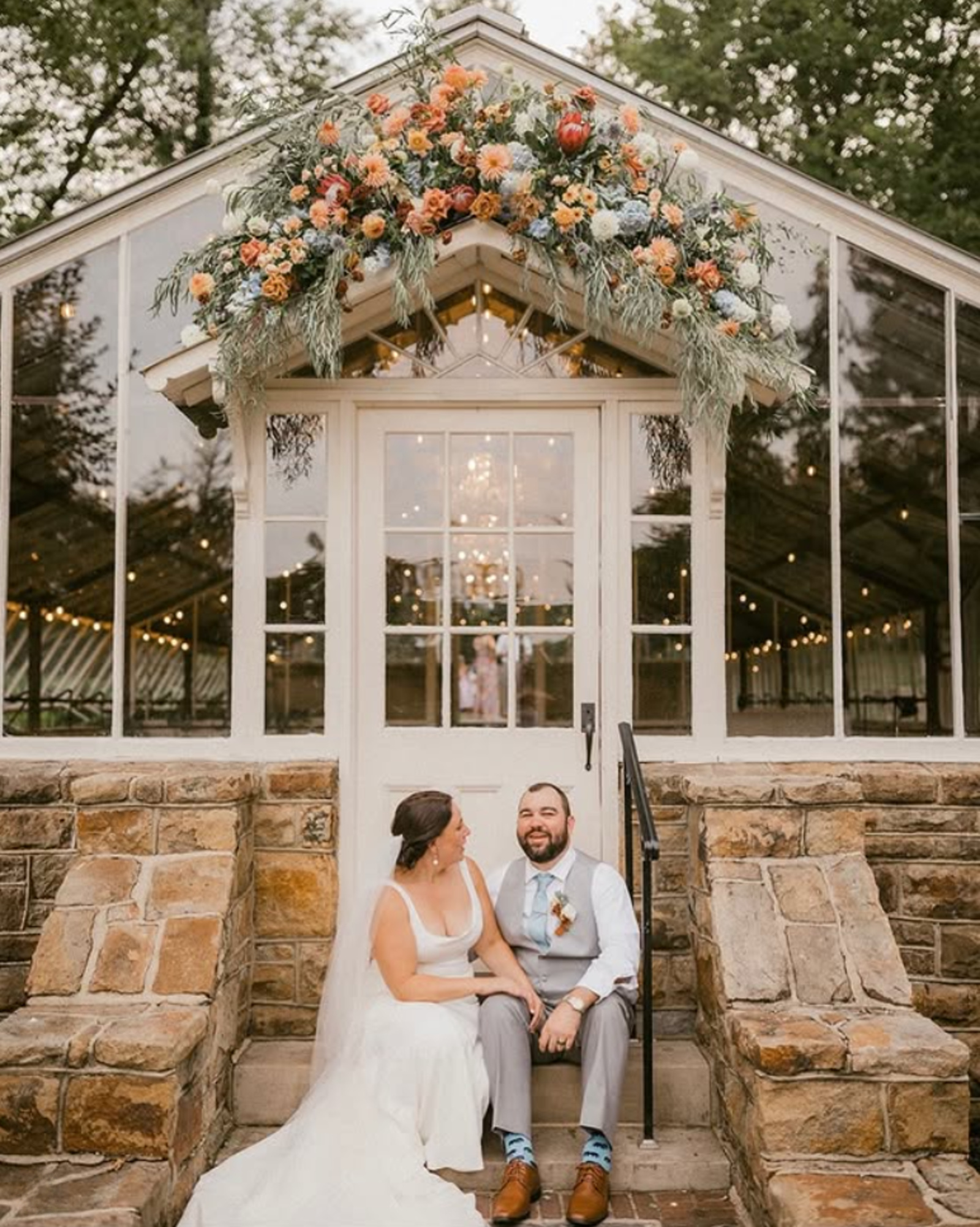 Historic Shady Lane Greenhouse Wedding Reception Bride and groom sitting outside the greenhouse reception space at Historic Shady Lane wedding venue