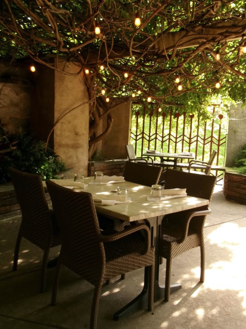 Outdoor patio dining at John J. Jeffries in Lancaster, PA, with tables beneath a vine-covered pergola and hanging string lights.