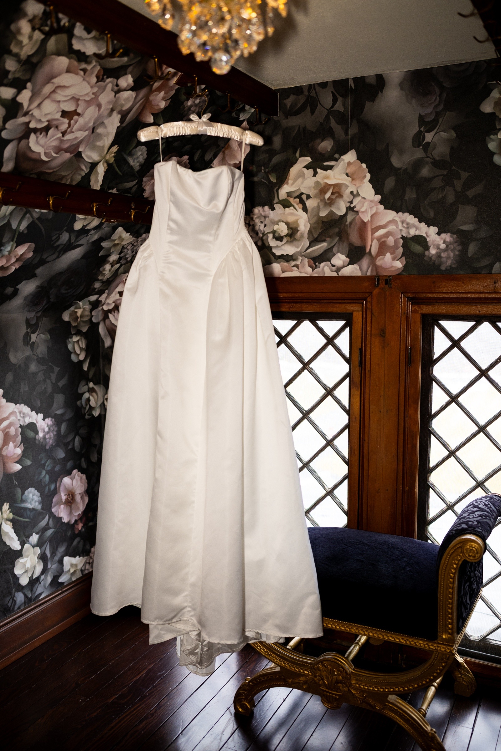 Simple satin wedding dress hanging in a bridal suite at The Willows at Ashcombe before a Pennsylvania elopement ceremony.