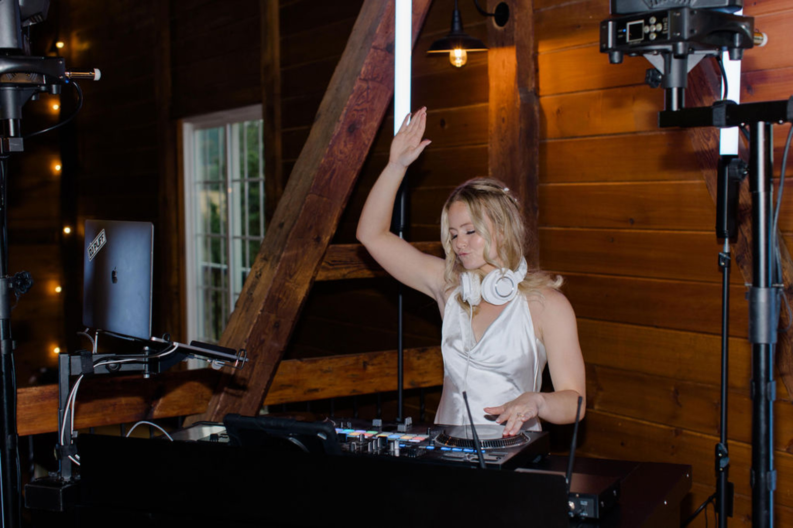Bride wearing a satin reception dress while DJing during the wedding reception inside Historic Ashland’s barn venue.