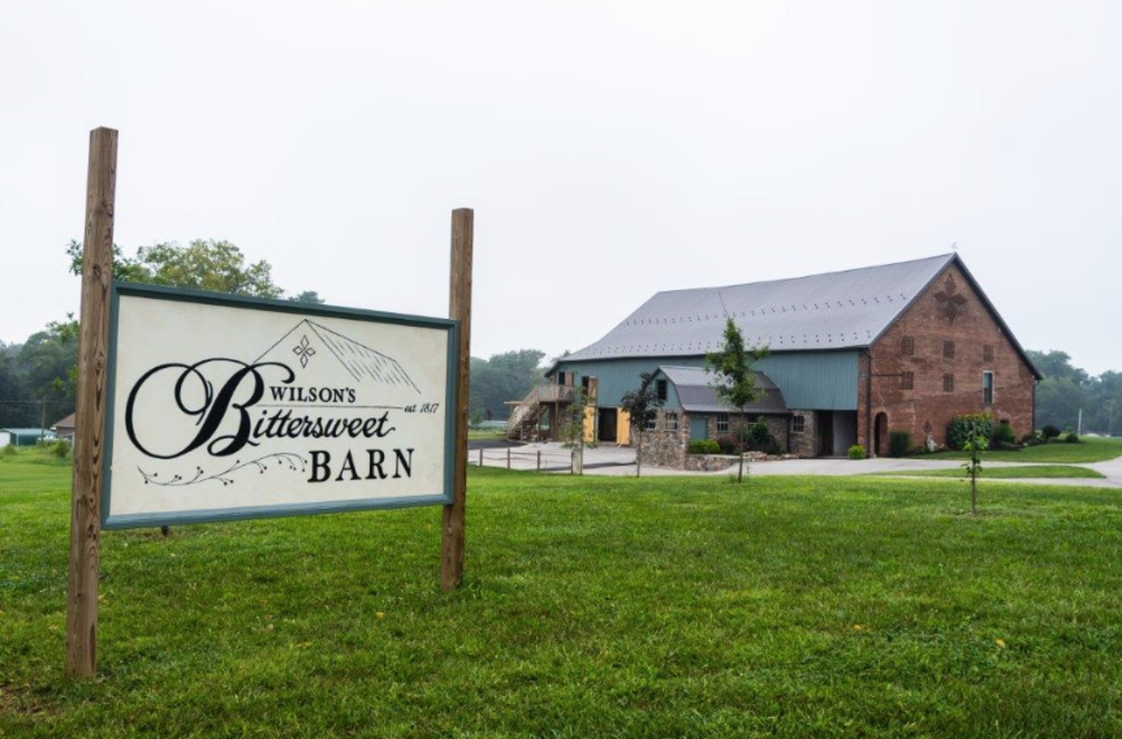 Wilson’s Bittersweet Barn wedding venue in New Oxford, PA, featuring its historic brick barn and venue sign.