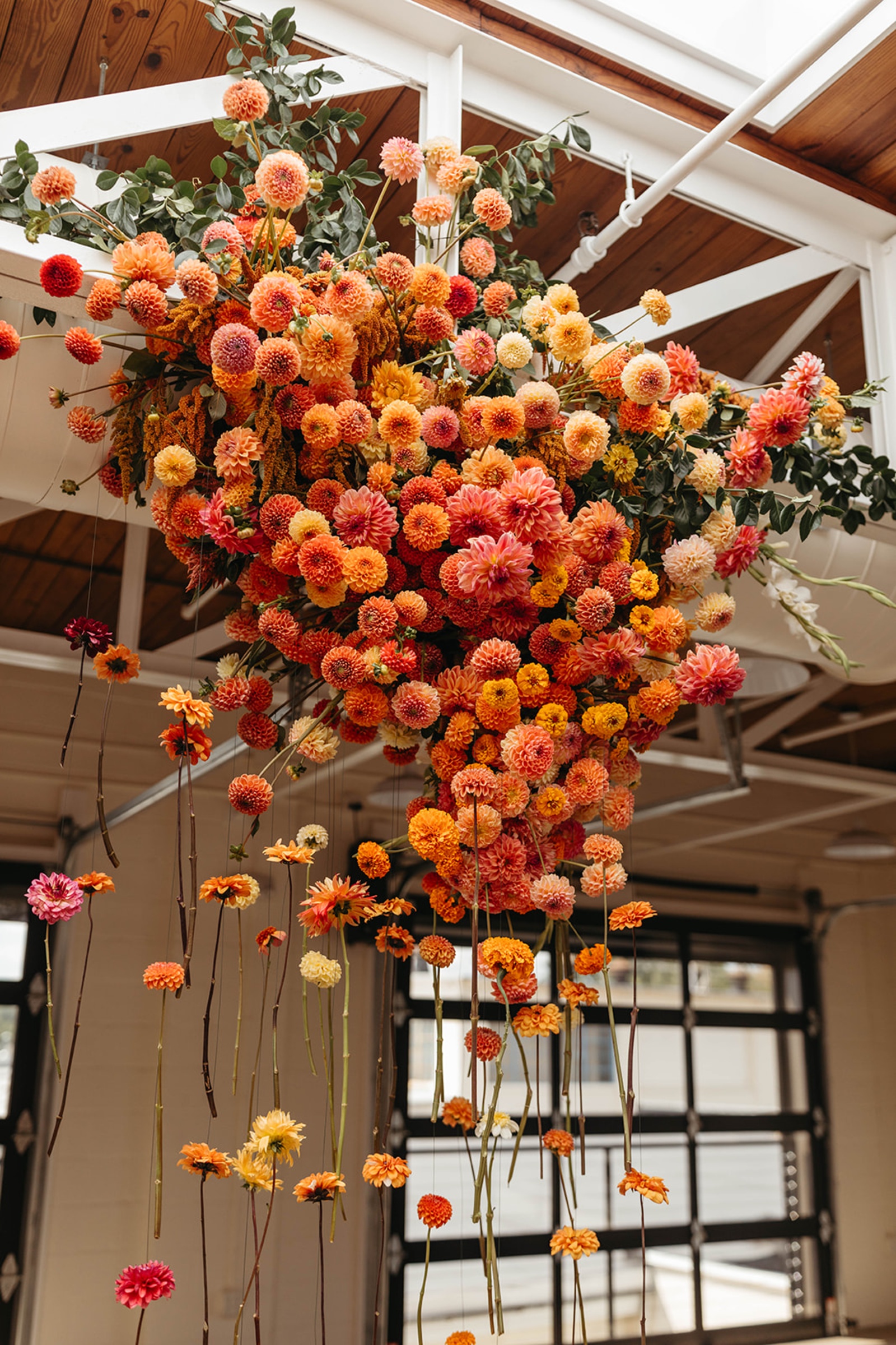Hanging Floral Installation at The Booking House Suspended orange, coral and peach floral installation hanging from the ceiling at The Booking House.