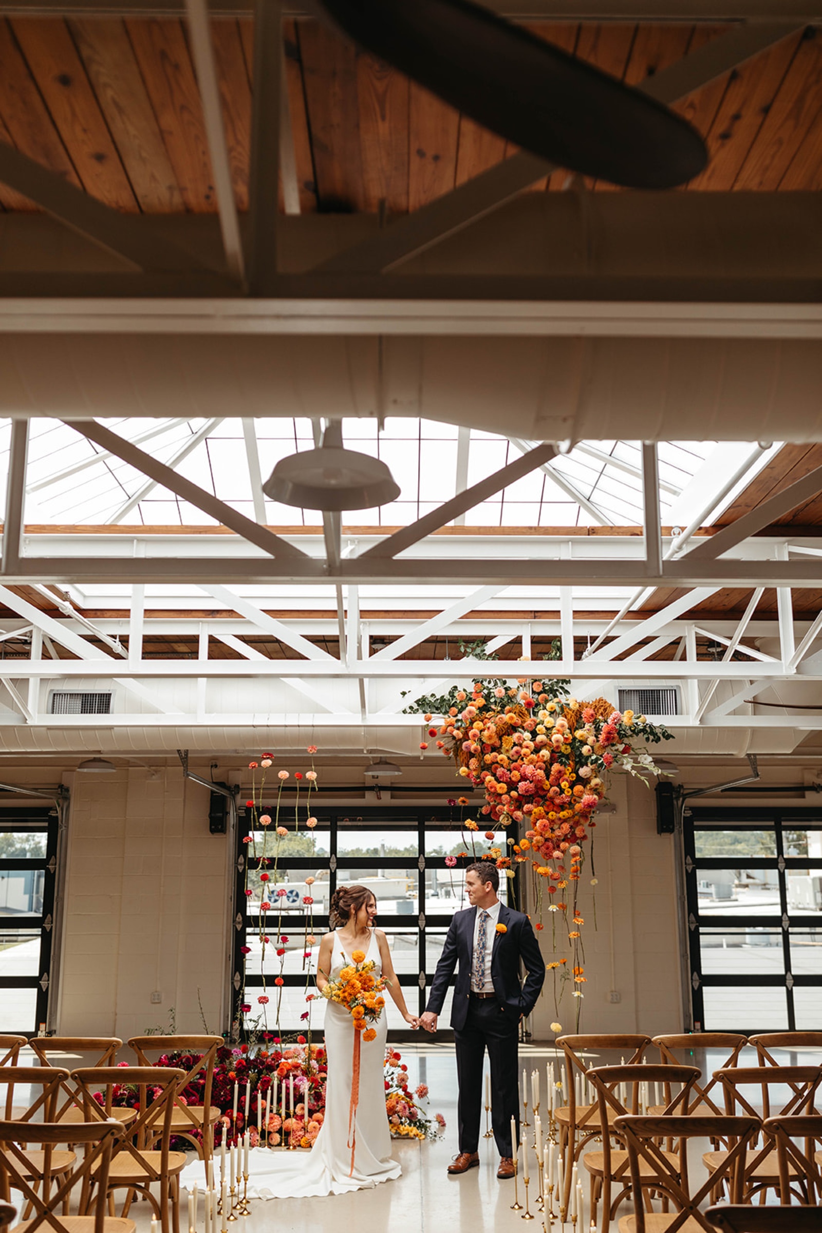 Suspended Floral Ceremony Installation Bride and groom standing beneath a suspended floral installation at The Booking House in Manheim, PA.