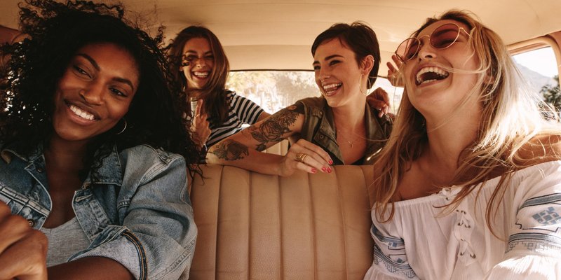 Friends laughing together on a bachelorette road trip in Central Pennsylvania, representing a fun and easy day-trip getaway for a modern bride.