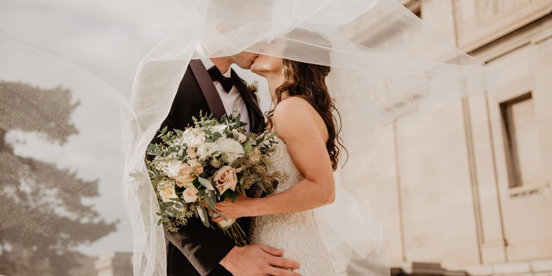 Romantic wedding photo of a bride and groom kissing under a veil, with soft neutral florals, perfect for a Pennsylvania wedding