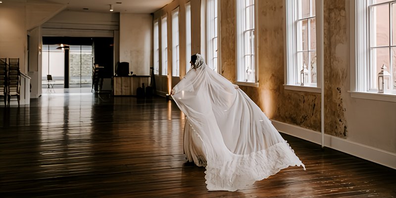 Bride showcasing a custom cathedral-length veil with lace trim in a warm, elegant Central Pennsylvania venue
