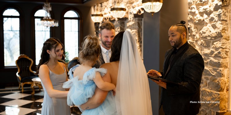 Bride and groom exchange vows during an intimate wedding ceremony at The Willows at Ashcombe in Pennsylvania with The Brofficiant officiating while their daughters stand beside them.