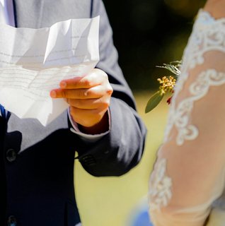Couple exchanging rings during an intimate self-uniting wedding ceremony surrounded by close family and friends in a warm, emotional setting.